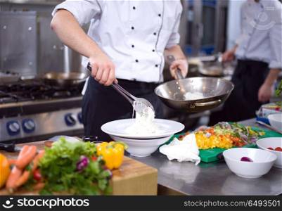 Chef hands serving spaghetti on restaurant kitchen. Chef hands serving spaghetti