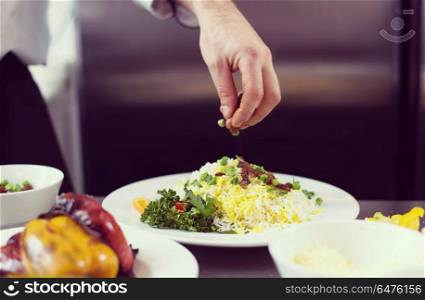 Chef hands serving vegetable risotto on restaurant kitchen. Chef hands serving vegetable risotto