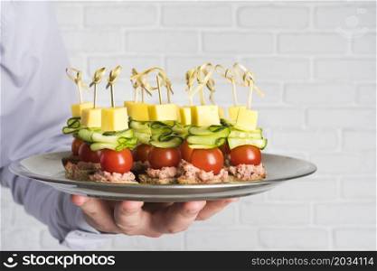 chef holding plate with catering food