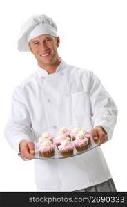 Chef in chef?s whites and toque holding cupcakes