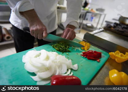 chef in hotel kitchen slice vegetables with knife and prepare food