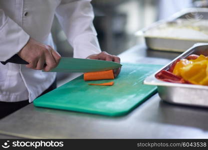 chef in hotel kitchen slice vegetables with knife and prepare food