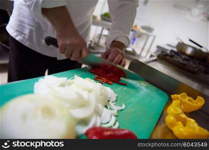 chef in hotel kitchen slice vegetables with knife and prepare food