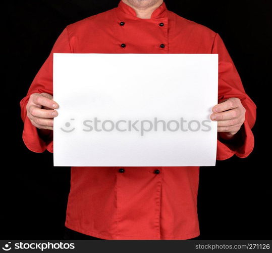 chef in red uniform holding a blank white paper sheet on a black background, copy space