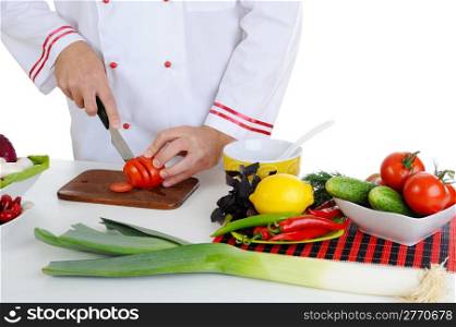 Chef in uniform cuts the vegetables. Isolated on white background