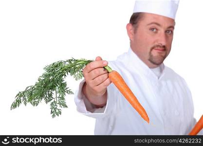 Chef in uniform offering forth a carrot