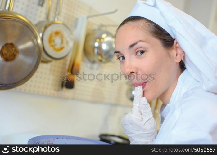 Chef licking gloved finger