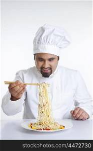 Chef lifting pasta with chopsticks
