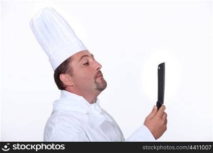 Chef looking at his reflection in a knife