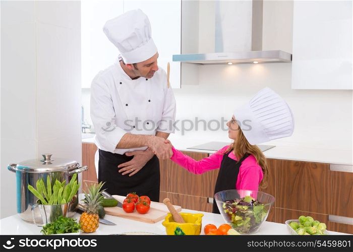 Chef master and junior pupil kid girl handshake at cooking school
