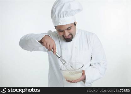 Chef mixing egg in bowl