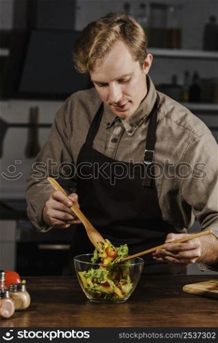 chef mixing salad ingredients