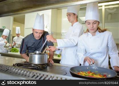 Chef observing trainee cooks