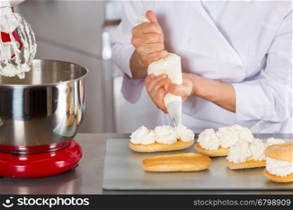 Chef pastry cream filling some biscuits