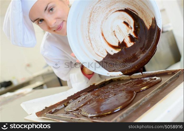 Chef pouring chocolate from bowl