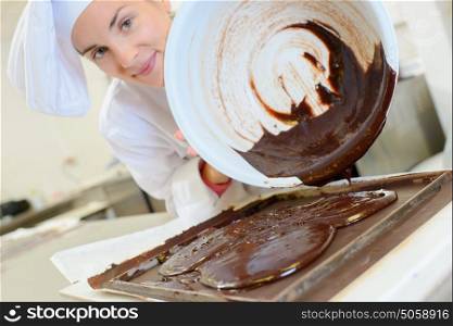 Chef pouring chocolate from bowl