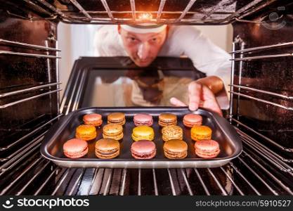 Chef prepares macarons in the oven, view from the inside of the oven. Cooking in the oven.