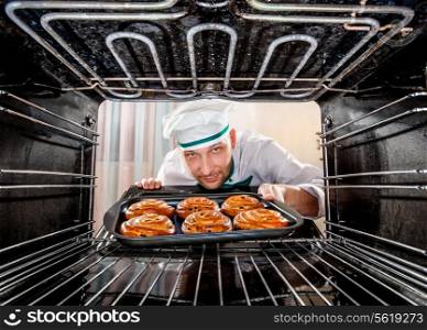 Chef prepares pastries in the oven, view from the inside of the oven. Cooking in the oven.