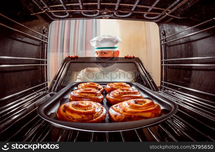 Chef prepares pastries in the oven, view from the inside of the oven. Cooking in the oven.