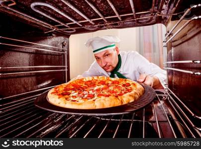 Chef prepares pepperoni pizza in the oven, view from the inside of the oven. Cooking in the oven.