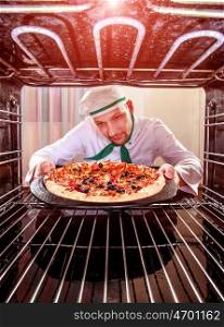 Chef prepares pizza in the oven, view from the inside of the oven. Cooking in the oven.