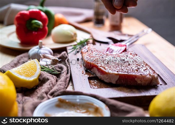 Chef prepares pork chop steak with barbecue sauce in the kitchen