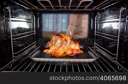 Chef prepares roast chicken (focus on chicken) in the oven, view from the inside of the oven. Cooking in the oven.Thanksgiving Day.