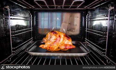 Chef prepares roast chicken (focus on chicken) in the oven, view from the inside of the oven. Cooking in the oven.Thanksgiving Day.