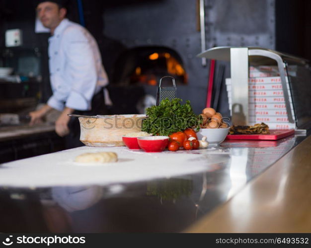 chef preparing dough for pizza rolling with hands on sprinkled with flour table. chef preparing dough for pizza