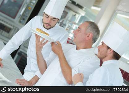chef preparing food in the kitchen with apprentices