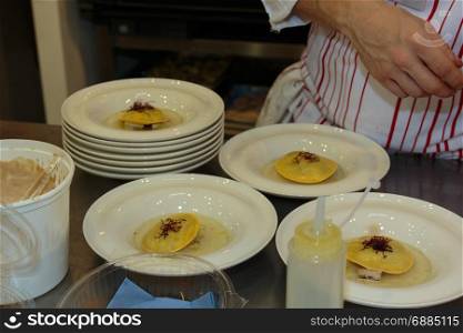 Chef Preparing Ravioli Italian Pasta with Red Vegetable with Sauce inside white Dishes