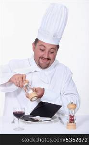 Chef seasoning the bill