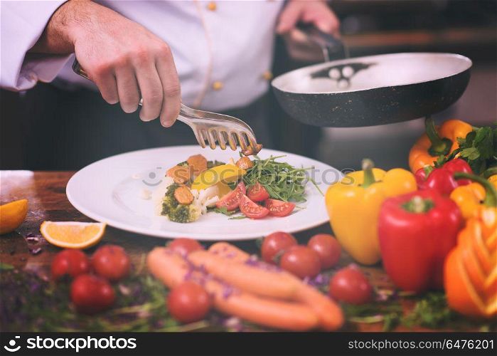 chef serving vegetable salad on plate in restaurant kitchen. chef serving vegetable salad