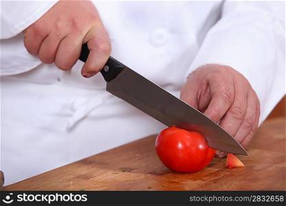 Chef slicing a tomato