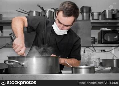 Chef stirring sauce in stainless steel pot, close-up. Professional kitchen, restaurant. High quality photo. Chef stirring sauce in stainless steel pot, close-up. Professional kitchen, restaurant.