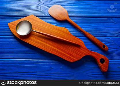 Chef tool wood spatula and table board on a blue wooden background