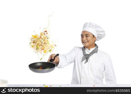 Chef tossing food in frying pan