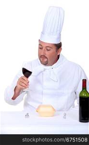 Chef with a glass of red wine and box of junk food