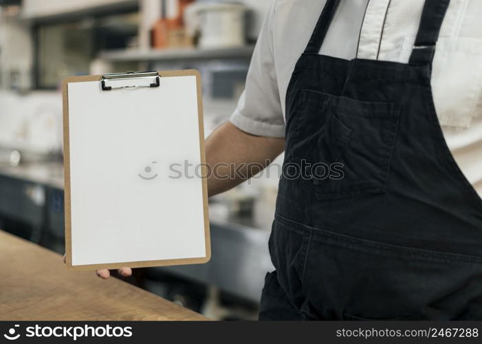 chef with apron holding clipboard