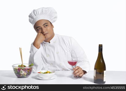 Chef with glass of wine thinking