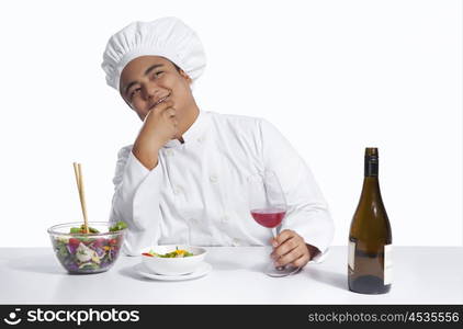 Chef with glass of wine thinking