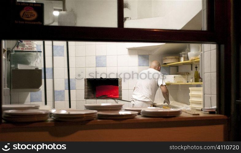 Chef works in kitchen, Villasimius, Sardinia, Italy