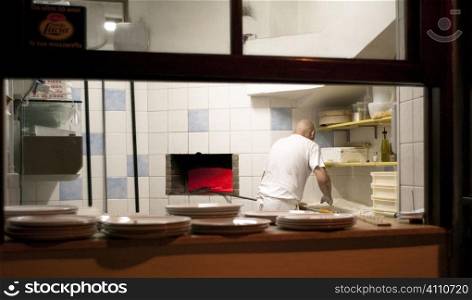 Chef works in kitchen, Villasimius, Sardinia, Italy
