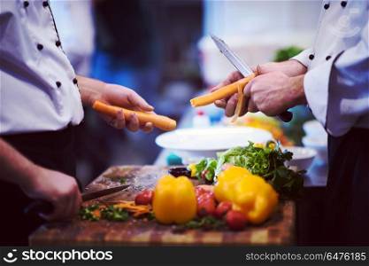 chefs hands cutting carrots on a wooden table preparation for meal at restaurant. chefs hands cutting carrots