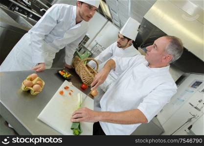 chefs in discussion while preparing vegetables