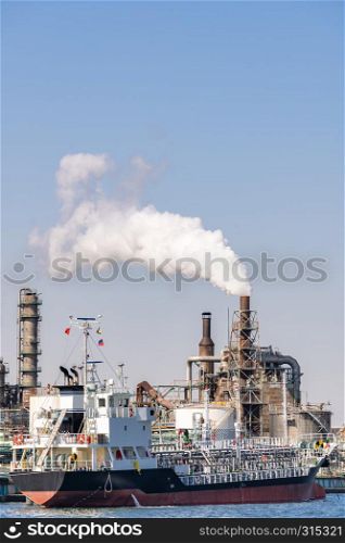 Chemical Factory plant with gas storage and structure of pipeline with smoke from smokestack in Kawasaki City near Tokyo Japan