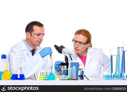 chemical laboratory with two scientist working with test tubes and microscope