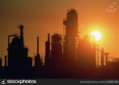 Chemical refinery plant and smokestacks in silhouette