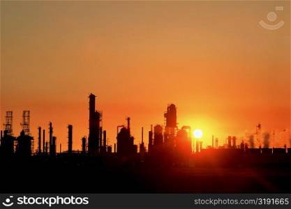 Chemical refinery plant and smokestacks in silhouette