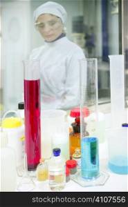 Chemical research laboratory, woman working, glass cylinder vase